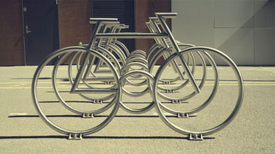 A modern stainless steel bike rack shaped like a bicycle.