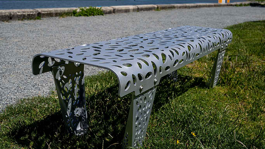 an aluminum bench temporarily installed in a grassy area