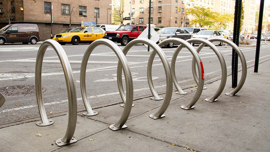 A row of metal bike racks installed on an urban street