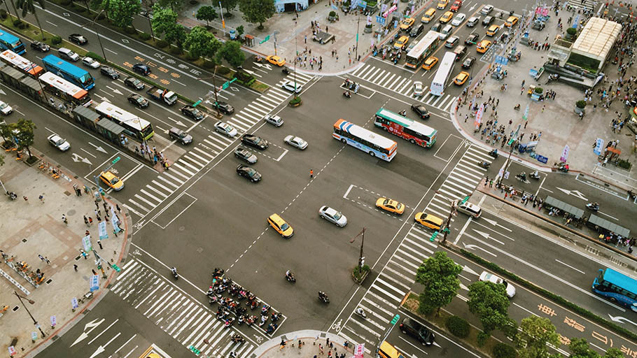 An overhead view of a busy intersection with multiple lanes and cars.