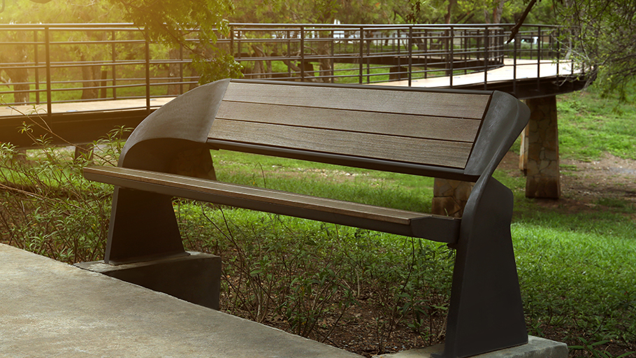 a uniquely styled bench on a walkway in a greenspace