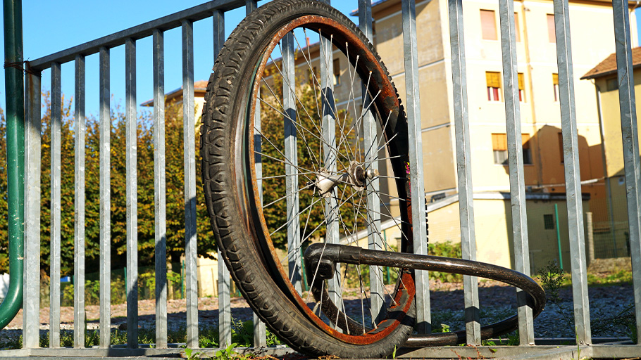 A bike wheel still locked to an old bike rack