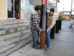 Two people installing R-1007-08 steel pipe security bollard