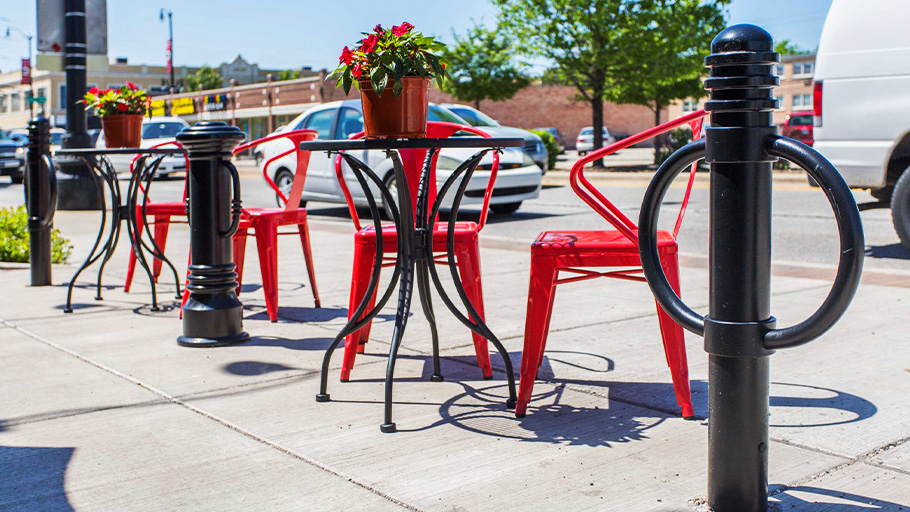 Bike bollards by Reliance Foundry installed in front of a restaurant beside outdoor seating