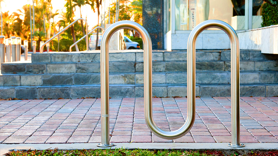 A Reliance Foundry wave style bike rack near the entrance stairs for a large building