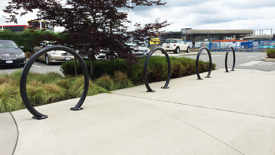 A row of Reliance Foundry R-8224 bike racks installed on a walkway.