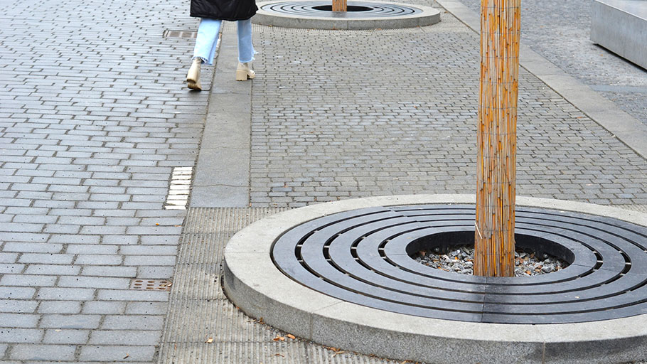 A round tree grate installed in an elevated concrete structure