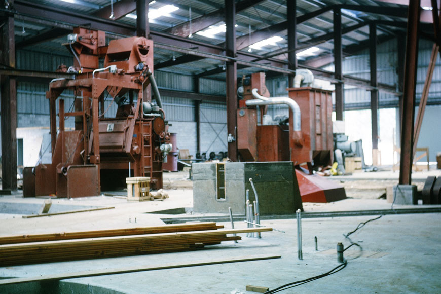 Large foundry machines are being installed onto the dirt of the foundry floor