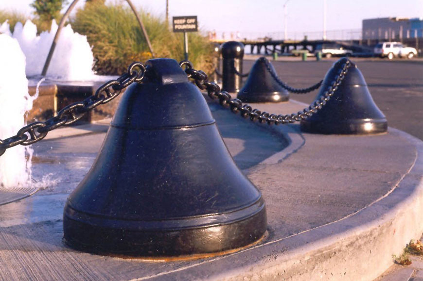 A series of bell bollards hooked together with chain protect a fountain