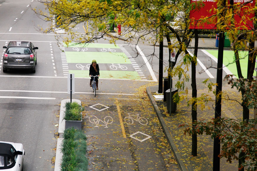 A cyclist rides in a protected bike lane in Vancouver, BC.