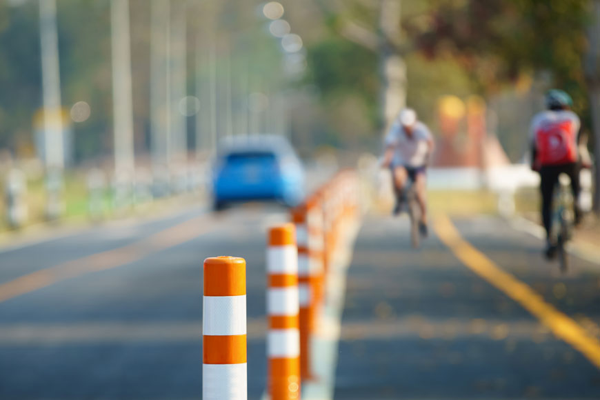 Orange and white flexible lane delineators mark a bike lane