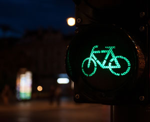 A close-up shot of a green bike-shaped traffic signal at night allowing bikes through