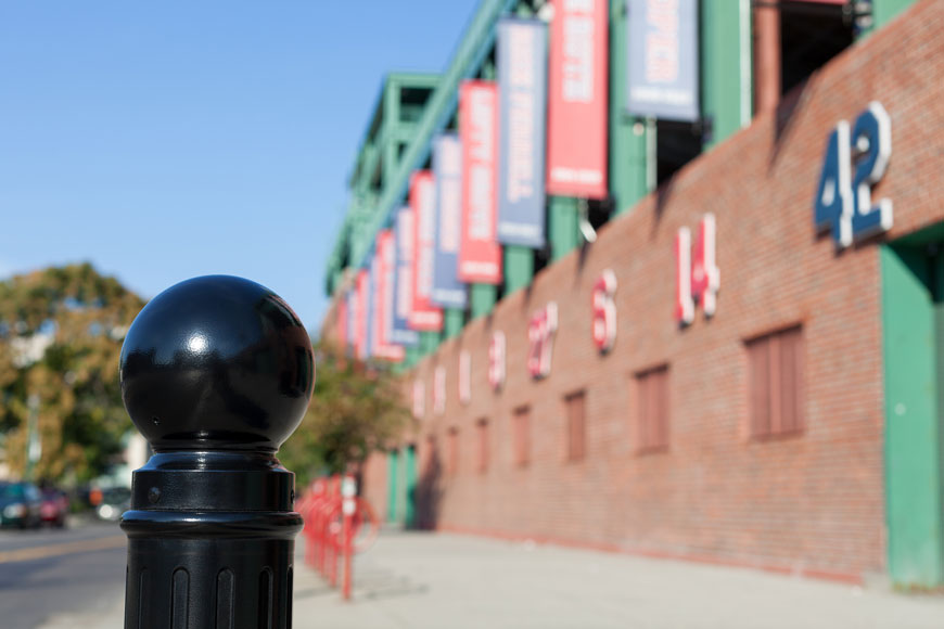 A close-up shot of a round black bollard cap outside Fenway Park in Boston.