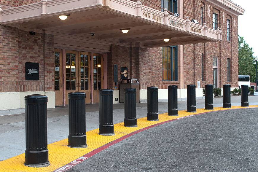 Bollards are installed into a line of yellow detectable warning plates