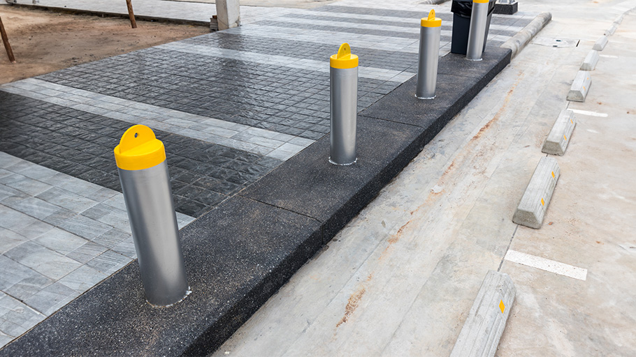 Bollards installed in front of parking spots to prevent vehicles from going beyond the designated parking area.