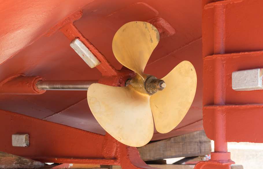 A bright brass ship propellor in dry dock