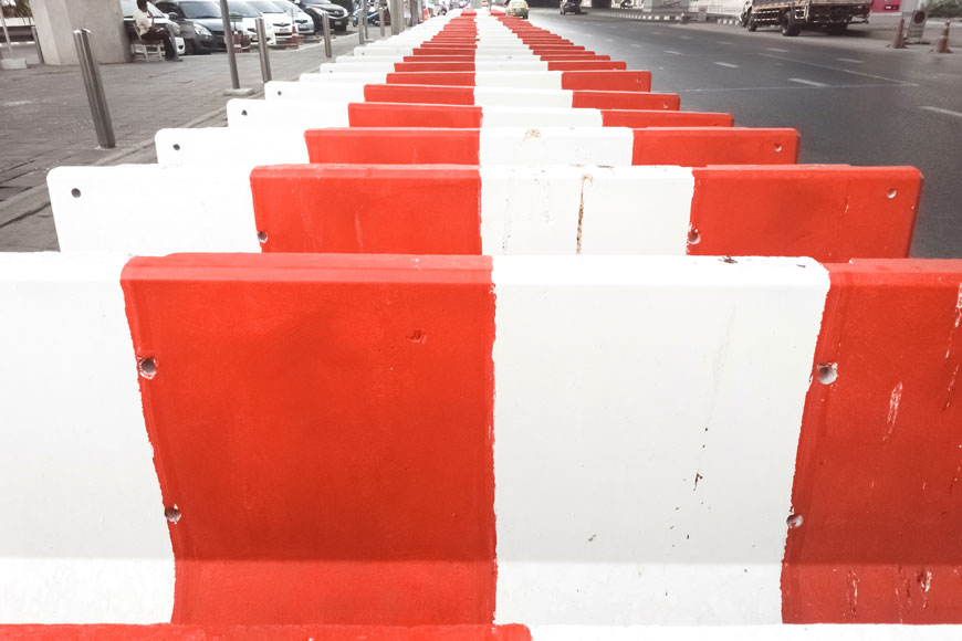 Red and white jersey barriers in a line before deployment