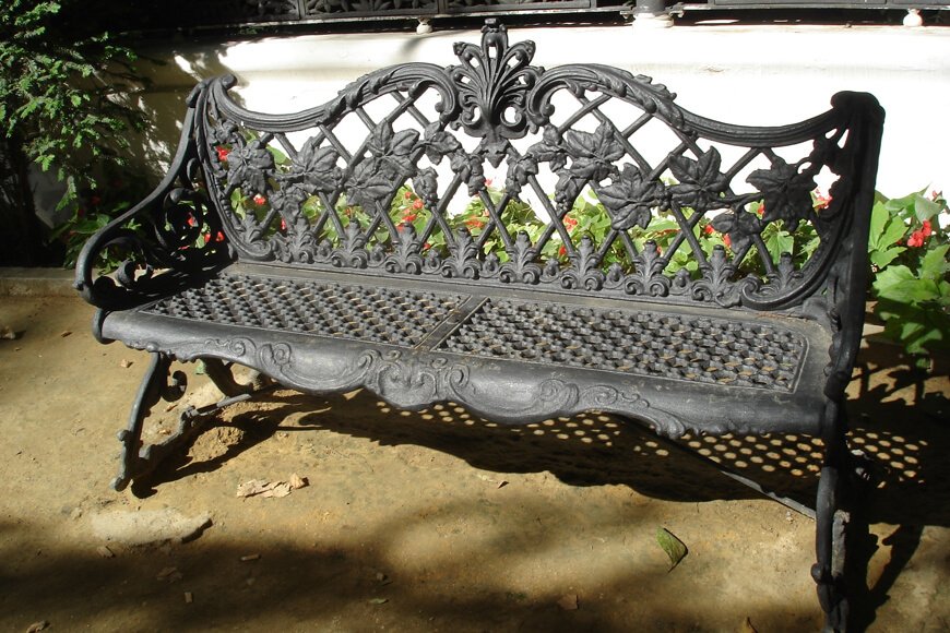 An antique cast iron bench shows the capacity for iron to be poured into very complex, ornate shapes