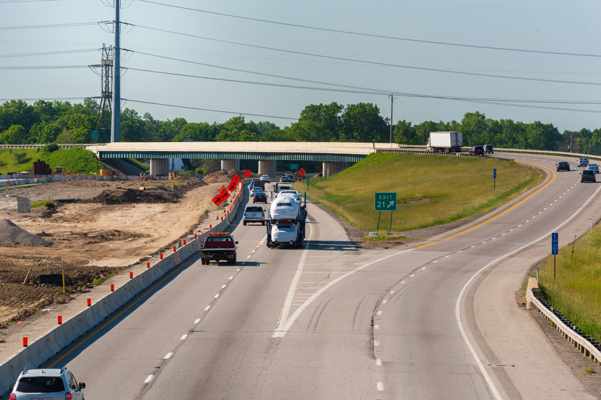 A line of cars passes by a newly set up construction site