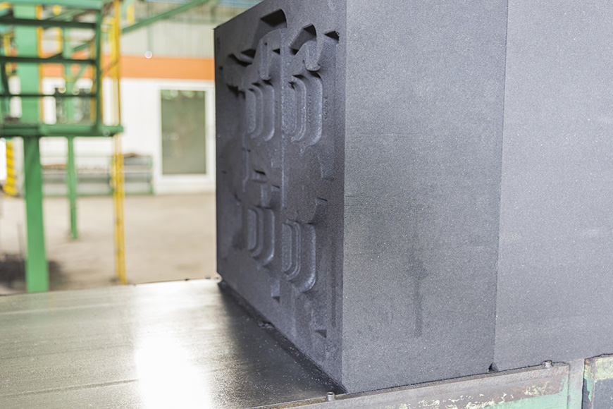 A mold cavity for a complex casting is pressed into the grey color sand in the swing of a vertical mold