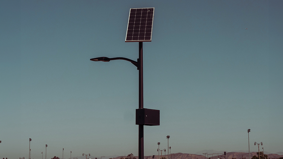 A street light equipped with a large solar panel for power.