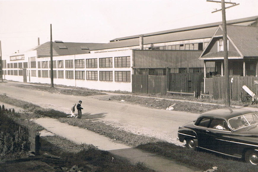 Two young boys play across the street from the factory