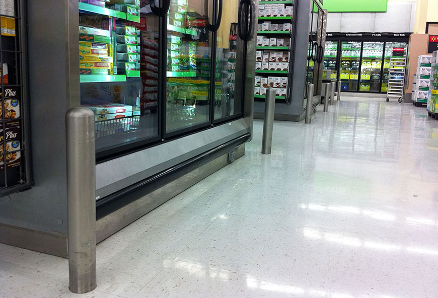 Stainless steel bollards protect freezers and fridges in a supermarket.