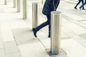 A pedestrian walks past a bollard