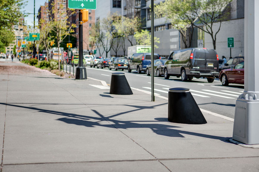 Two Martello bollards with a slope facing traffic guard a pedestrian ramp to the sidewalk