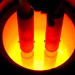 An electric arc furnace glows red as it heats steel above the melting point of 2500°F