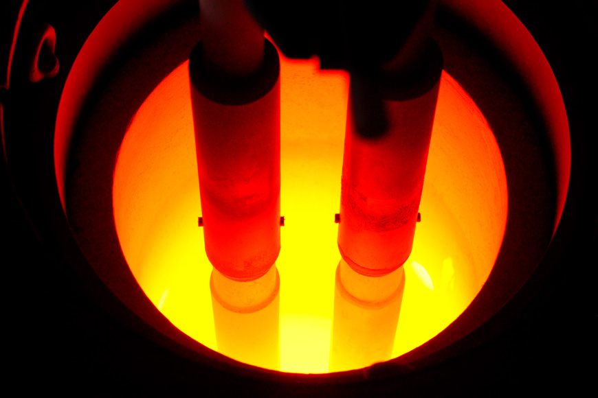 Two electrodes at least 10” in diameter glow with heat in a metal melting furnace