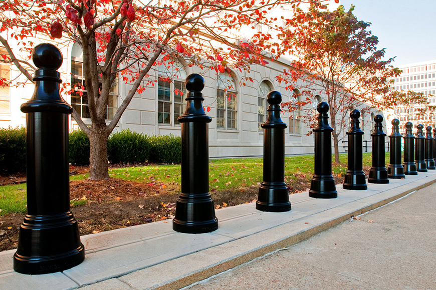 A series of tall black metal post covers give the look of chess pawns to security bollards