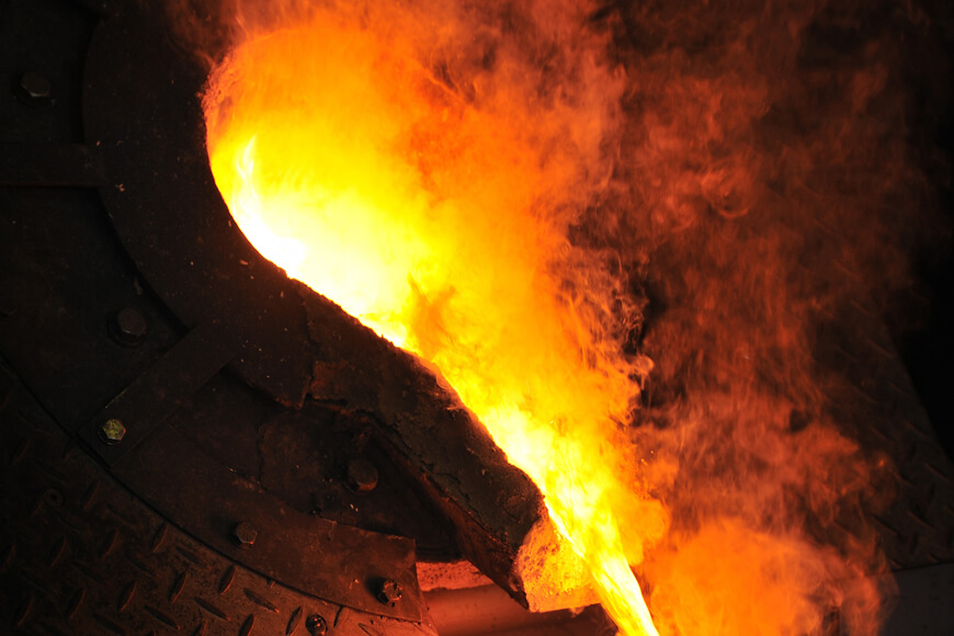 Molten metal being emptied out of a furnace into a pouring ladle