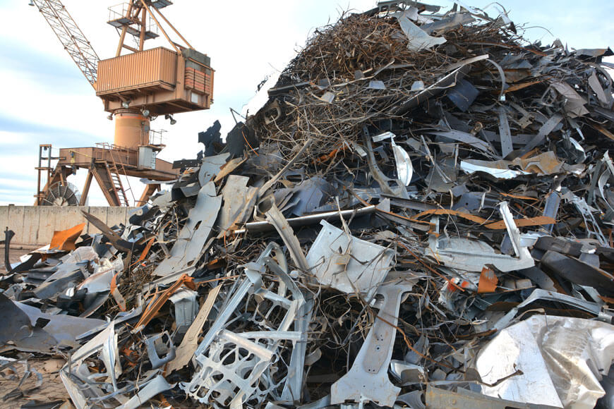 A metal recycling facility shows a metal scrap yard with a large pile of scrap metal