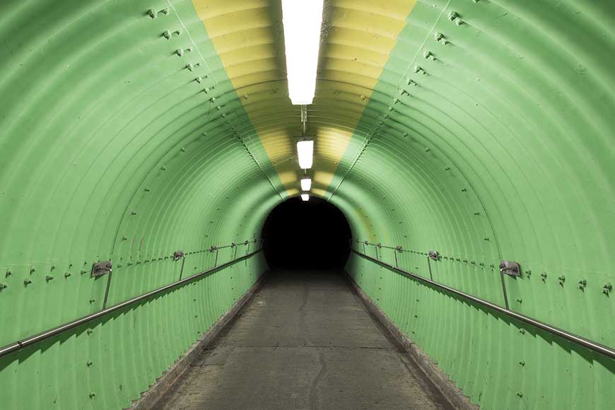 Overhead lights illuminate a pedestrian tunnel
