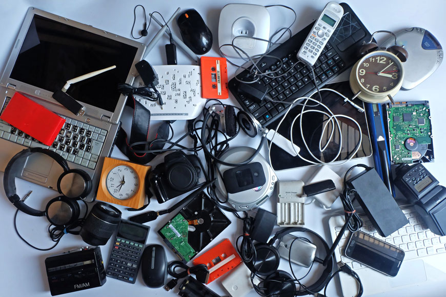 A pile of old technological devices like phones and laptops