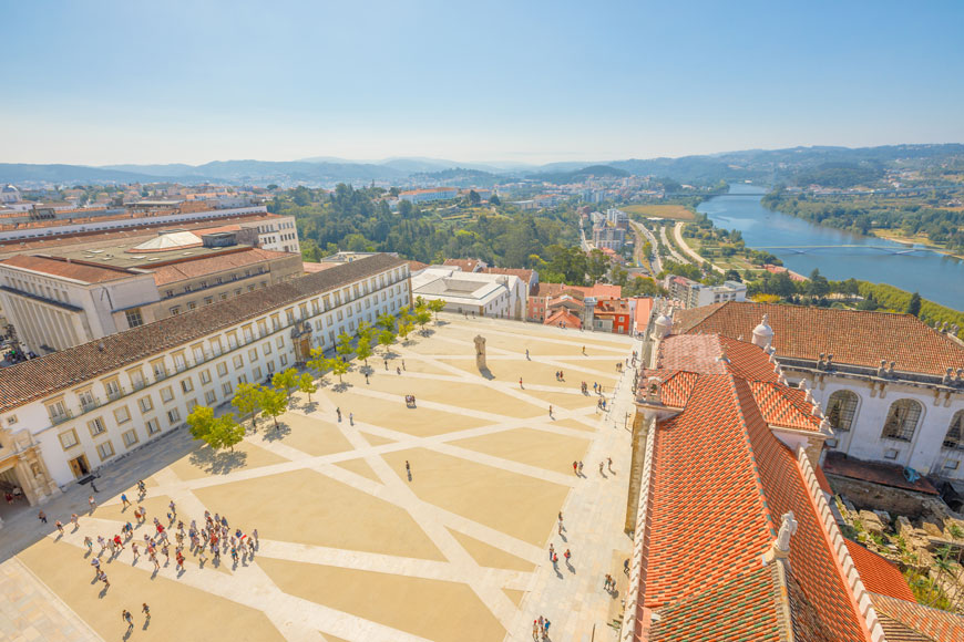 Coimbra University courtyard has crisscrossed stonework paths and a river vista