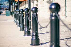 A row of Reliance Foundry’s decorative bollards that feature fluting are shown close up on a historic sidewalk.