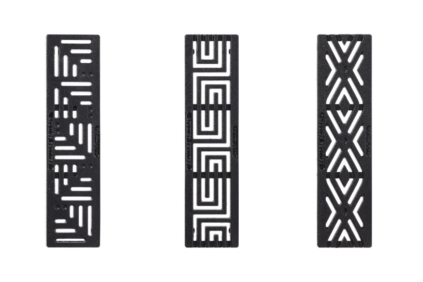 Tres tomas de estudio de rejas decorativas con motivos de ranuras angulares, pintadas de negro.