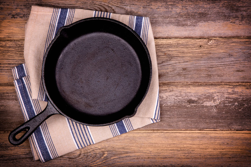 A clean cast iron pan sits on a towel