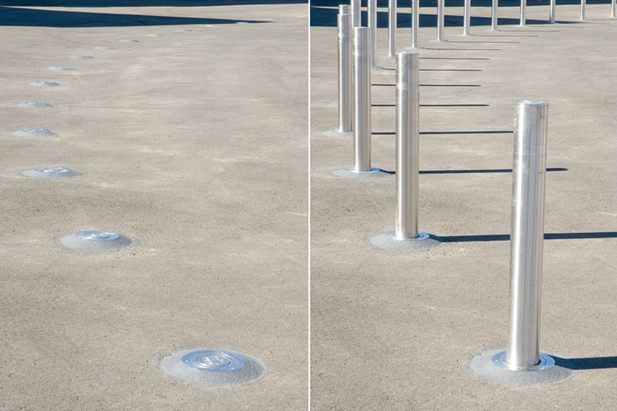A ring of stainless steel retractable bollards are shown side-by-side in down and up positions
