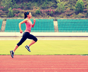 Woman running on track wearing spandex clothing