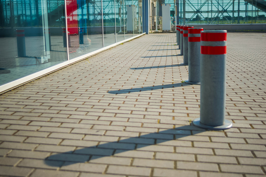 a line of steel bollards protect an airport window