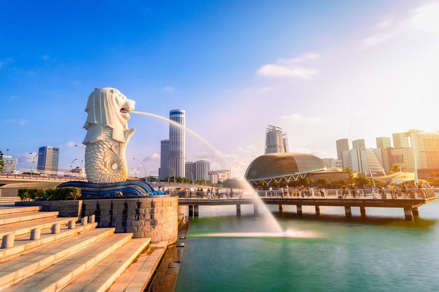 Singapore’s Merlion statue shoots water in front of sunrise skyline