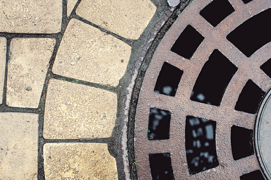 Cast iron sewer grate with dark oxidation