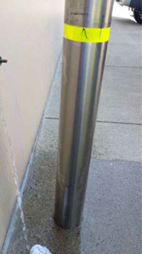 A gleaming bollard standing outside after a rinse with water