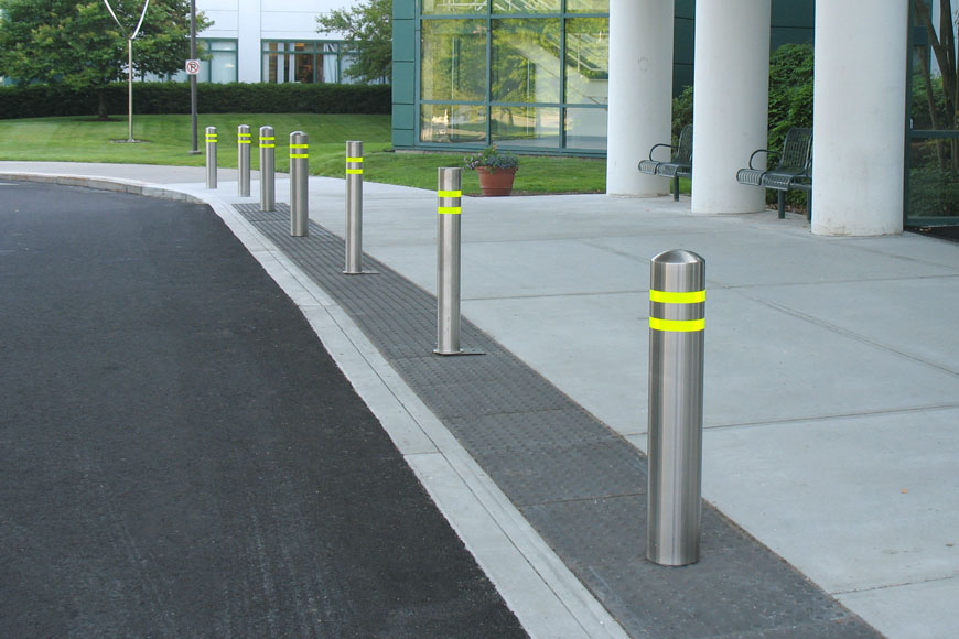 Stainless steel bollard covers with reflective strips outside a hospital