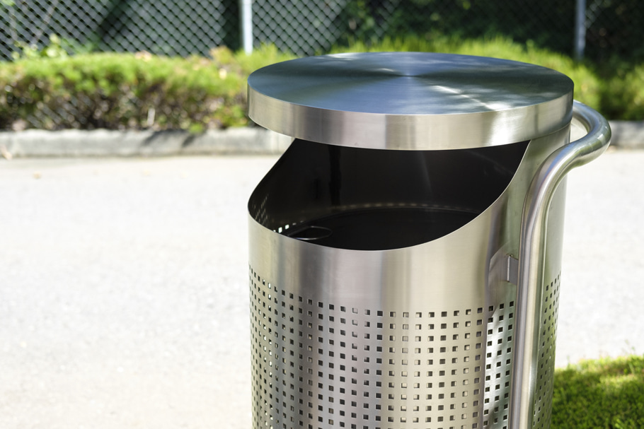 The R-5002 Seattle trash can provides secure trash disposal in a parking lot.