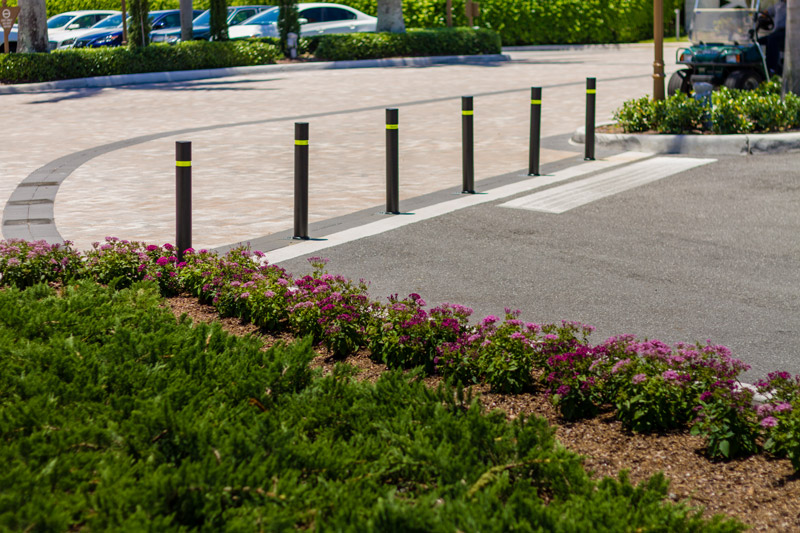 A series of flexible bollards marks off an authorized vehicle only bay
