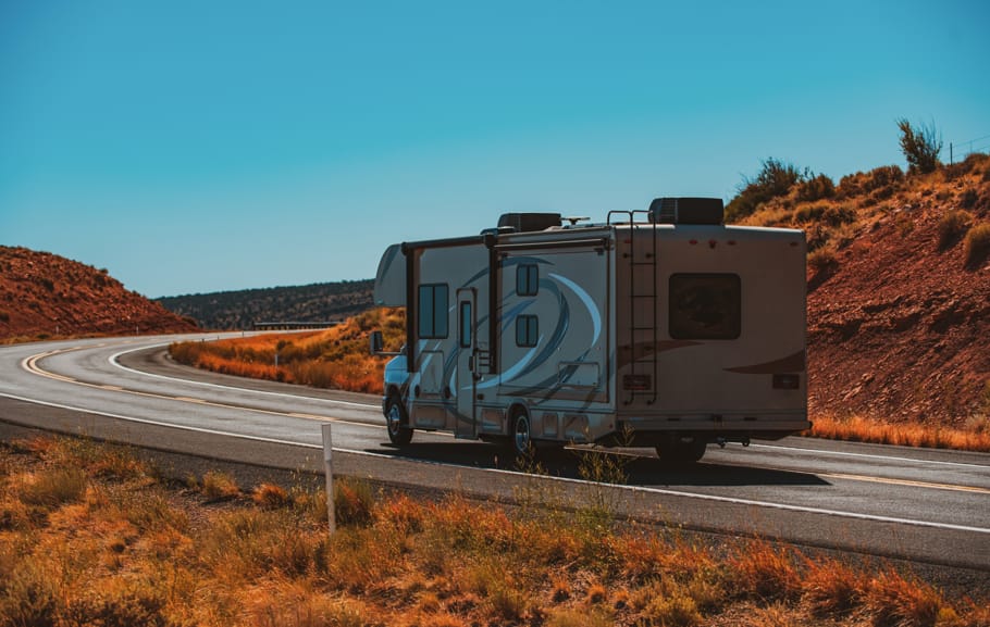 A camper van travels along a desert road